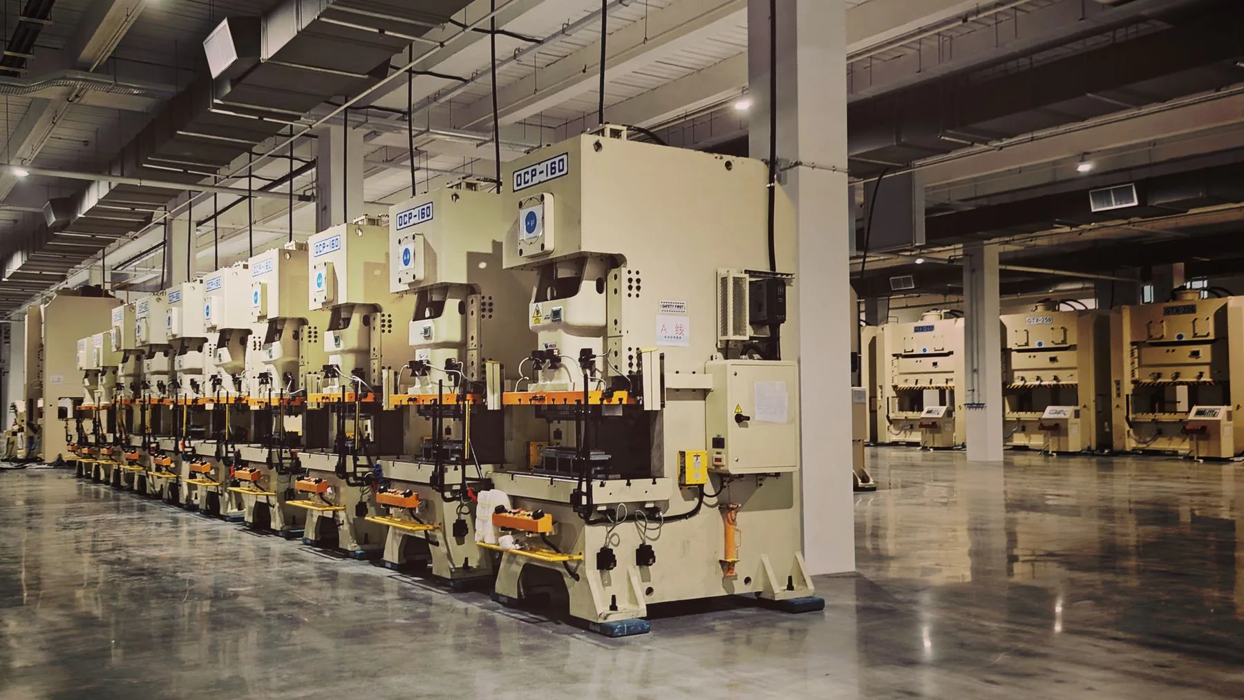 Üretim tesisinde sıralanan hidrolik presler ve endüstriyel makine hatları